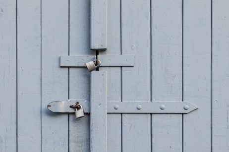 two steel locks on a wooden door